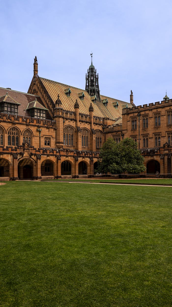 The iconic sandstone architecture of the University of Sydney Quadrangle on a clear day, a symbol of academic excellence.